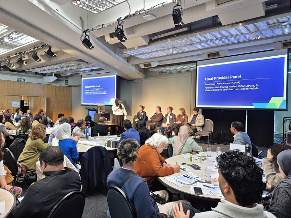Image of a panel of local education providers seated in front of an audience, sharing their successes and challenges.