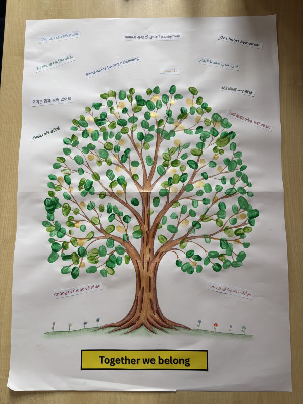 Student artwork showing a large tree surrounded by words and greetings in different languages. The tree represents friendship, growth and belonging, while the different languages celebrate the unique cultures and identities within the school community. The artwork reflects the theme “Together we belong” and the message of growing together as friends while celebrating our unique languages.