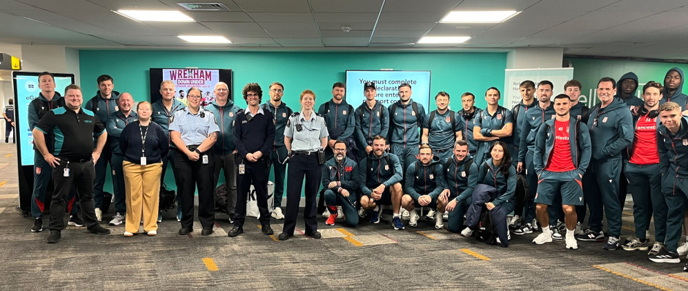 Image of Wrexham football team in the Wellington airport with airport staff.