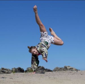Dancer balancing on one hand in an outdoor setting